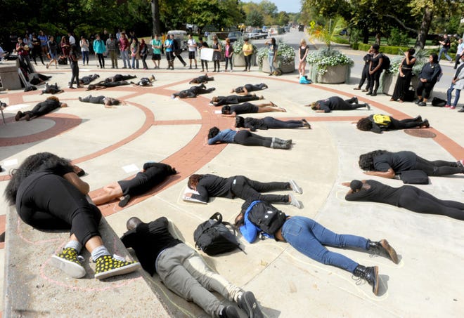 About 21 University of Missouri students mostly dressed in black lie motionless Wednesday during an MU4 Mike Brown rally at Speakers Circle. Members of the group also read poems about white police oppression against blacks and read names of people killed in confrontations with police.