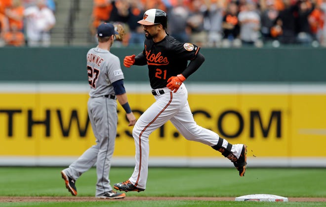 Baltimore Orioles' Nick Markakis, front, rounds the bases past Detroit Tigers shortstop Andrew Romine after hitting a two-run home run in the third inning of Game 2 in baseball's AL Division Series in Baltimore, Friday, Oct. 3, 2014. (AP Photo/Patrick Semansky)