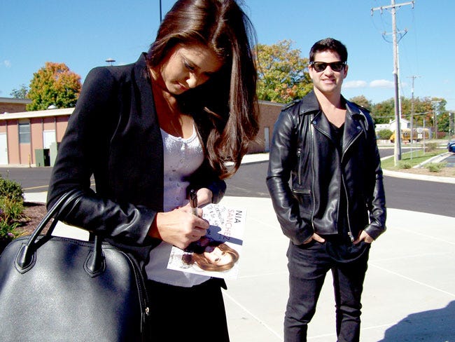 Nia Sanchez, Miss USA 2014, signs an autograph Wednesday outside Centreville High School. She and her fiancée, Daniel Booko, both gave inspirational words to students at the school, as well as high schools in Constantine and Three Rivers.