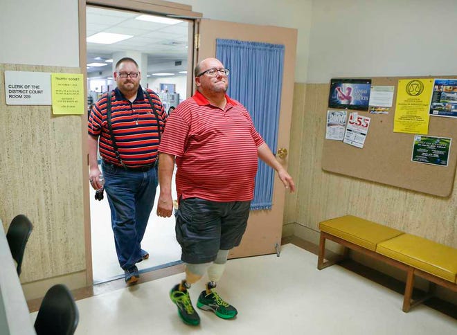 Wade Honey, right, and Dan Barnes, a gay couple, leave the office of the Shawnee County District Court Clerk after being denied a marriage license Monday afternoon. Thursday, the clerk's office announced it would accept applications, although it would be unable to issue licenses until Kansas law is changed.