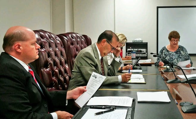 Shawnee County Commissioners Kevin Cook, Bob Archer and Shelly Buhler listen Thursday as public works director Tom Vlach informs them about the budget for an upcoming street expansion project.