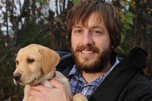 Justin Priest holds his 9-week-old yellow lab Lily in Anchorage on Thursday, Oct. 9, 2014. Early in the morning Alaska State Troopers told a family in Palmer that their son Justin had died in a Juneau car accident. When the family knocked on the door to tell his girlfriend in Anchorage Justin answered the door causing a flood of emotions in the case of mistaken identity. (AP Photo/The Alaska Dispatch News, Bill Roth)