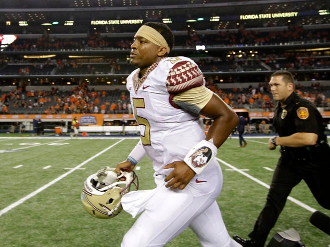 In this Aug. 30, 2014 file photo, Florida State quarterback Jameis Winston (5) runs off the field following their NCAA college football game against Oklahoma State in Arlington, Texas. Winston avoided criminal charges after a woman accused him of sexual assault. But the Florida State quarterback could possibly face a lawsuit and potential punishment from the university looms.