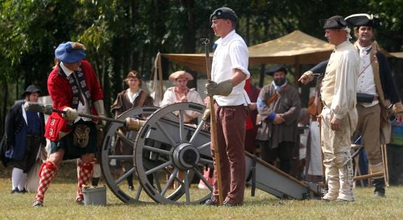 Re-enactors prepare a cannon to be fired for the 2014 Gateway Festival at Kings Mountain’s Patriots Park on Saturday.