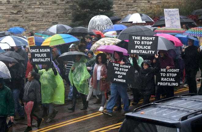 Protesters march in the streets of Clayton, Mo., near the St. Louis County Courthouse, protesting the police shooting of Michael Brown, Friday, Oct. 10, 2014. Protesters want prosecutors to file criminal charges against the white municipal police officer who fatally shot the unarmed Brown. (AP Photo/Charles Rex Arbogast)