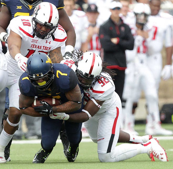 Texas Tech's Andre Ross and Pete Robertson(10) tackle West Virginia's Rushel Shell during their game on Saturday in Lubbock. (Tori Eichberger/AJ Media)