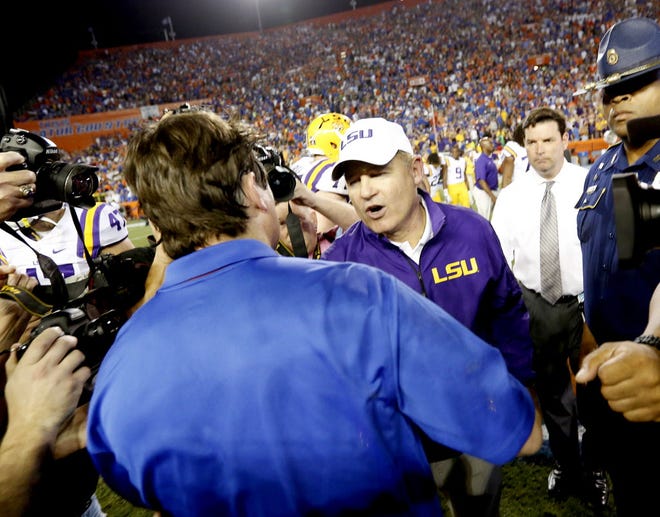 LSU Tigers head coach Les Miles shakes hands with Florida Gators head coach Will Muschamp after the second half at Ben Hill Griffin Stadium on Saturday, Oct. 11, 2014 in Gainesville, Fla. LSU defeated Florida 30-27.