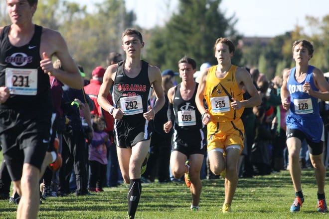 Saranac senior Brendan Klynstra (black jersey), Pewamo-Westphalia senior Caleb Barker (yellow jersey), and Ionia senior Peter Pelon (blue jersey) all look for their strides during the Greater Lansing Cross Country Championships on Saturday in Grand Ledge.