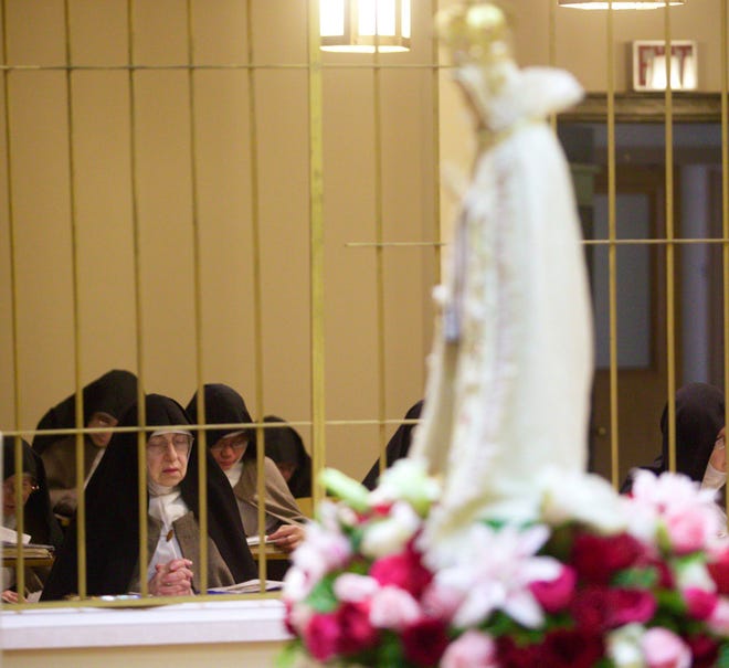 Cloistered nuns from Corpus Christi Monastery of the Poor Clare Colettine pray Monday, Oct. 13, 2014, during a Mass in celebration of Our Lady of Fatima and the Miracle of the Sun.