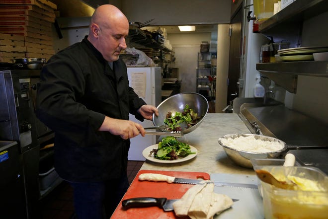 Chef Michele Massimo prepares a salad in the kitchen of his restaurant Botto Bistro Wednesday, Oct. 1, 2014, in Richmond, Calif.