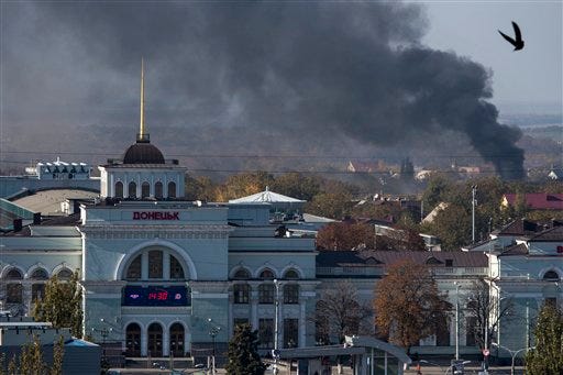 Smoke rises behind Donetsk train station, not far from the Donetsk Sergey Prokofiev International Airport, during an artillery battle between pro-Russian rebels and Ukrainian government forces in the town of Donetsk, eastern Ukraine, Sunday, Oct. 12, 2014. Donetsk airport is the focus of much of the fighting but has no immediate tactical significance for separatist forces who are devoid of any air power. (AP Photo/Dmitry Lovetsky)