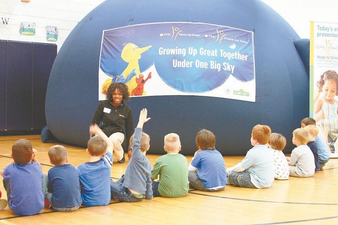 Nefertiti Opoku, tour manager for the PNC One World, One Sky Program, prepares Cheboygan East Elementary kindergarten students for a trip to the moon inside an inflatable planetarium for the Growing Up Great Together Under One Big Sky tour that came to the school on Monday. Head Start students, along with kindergarteners from East Elementary, got the chance to “visit the moon” inside the planetarium, with Sesame Street characters teaching math, geometry, physics astronomy, and awareness of other cultures in a 27-minute video.