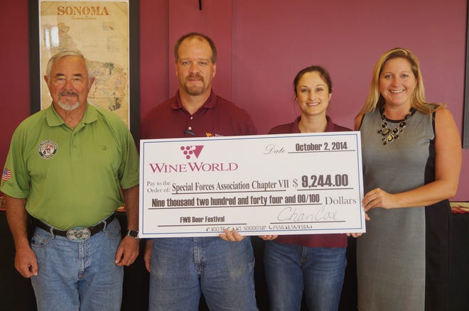 From left, Lt. Col (Ret) Sam Smith, treasurer of the Special Forces Association, Chapter 7; Jet Thompson, general manager of Wine World at Uptown Station; Suzanne Williams, Wine World associate; and Dina Bevis, property manager of Uptown Station at check presentation.