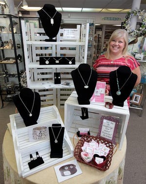 At Artisans in the Square in Hingham, Elisa Sullivan of Swirls Jewelry shows off pieces that she has created.