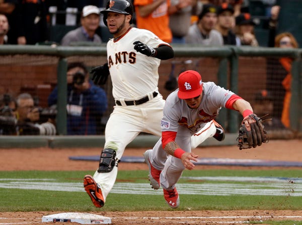 San Francisco Giants' Gregor Blanco is safe at first as St. Louis Cardinals second baseman Kolten Wong fails to catch the throw during the 10th inning of Game 3 of the National League Championship Series on Tuesday in San Francisco. (Jeff Chiu | Associated Press)