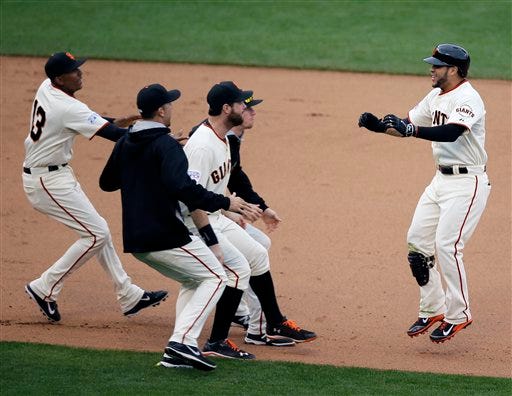 San Francisco Giants' Gregor Blanco, right, celebrates after hitting the game winning sacrifice bunt during the 10th inning of Game 3 of the National League baseball championship series against the St. Louis Cardinals Tuesday, Oct. 14, 2014, in San Francisco. (AP Photo/Eric Risberg)