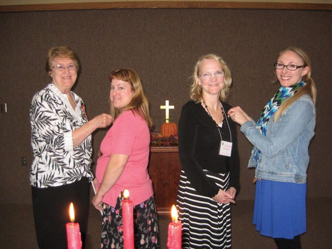 Pictured are, from left, President Carol Hoffman (left) attaches the DKG pin to Patty Benson while Member Jessica Lawson (Washington) pins Debbie Hitchens at the conclusion of the initiation ceremony.