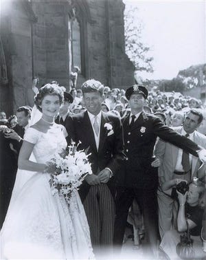 In this Sept. 12, 1953 photo released by RR Auction, John F. Kennedy, Jr., and his new bride Jacqueline leave St. Mary's Roman Catholic Church after their wedding in Newport, R.I. The photo is one of a collection of 13 original images made by Frank Ataman, of Fall River, Mass., being auctioned by RR Auction. The original negatives were discovered in his darkroom after he died. The auction closes Wednesday, Oct. 15, 2014. (AP Photo/RR Auction, Frank Ataman)