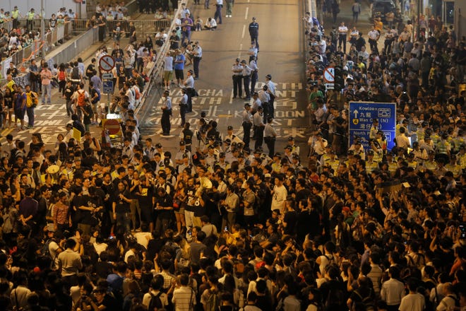 People protest outside a police station after a clash between protesters and police near a occupied area Wednesday in Hong Kong. Hundreds of Hong Kong police officers drove protesters from an underpass early Wednesday, the worst violence since the street demonstrations for greater democracy began more than two weeks ago.