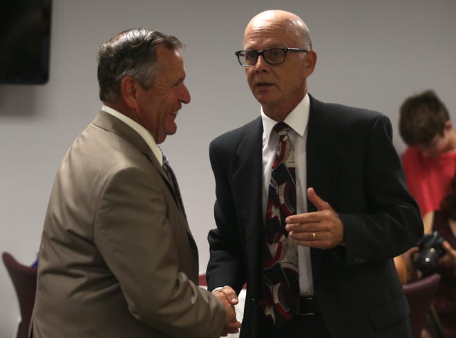 Councilman Bob Pelletie shakes hands with Mayor Thomas Abbott in an earlier Callaway Commission meeting.