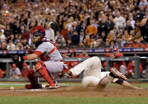 San Francisco Giants' Juan Perez, right, scores past St. Louis Cardinals catcher A.J. Pierzynski on a hit by Gregor Blanco during the sixth inning of Game 4 of the National League baseball championship series Wednesday, Oct. 15, 2014, in San Francisco. (AP Photo/Jeff Roberson)