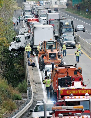 A jackknifed tractor trailer's cab hangs over the PA Turnpike Thursday after crashing into the guardrail in Bristol Township.