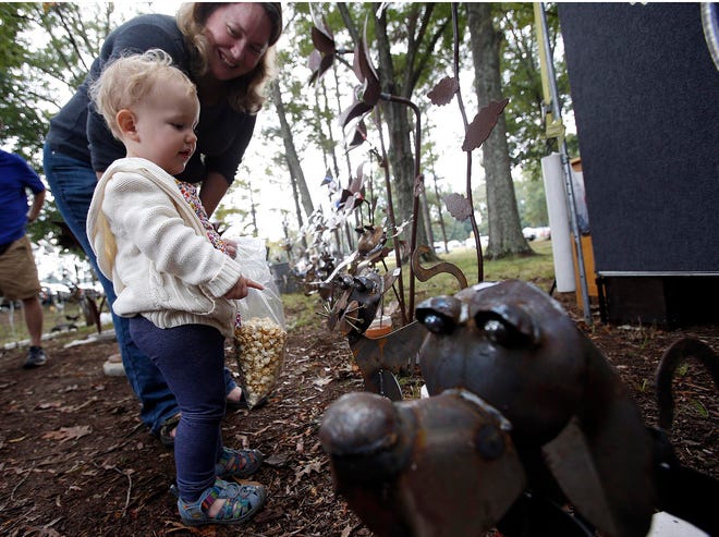 FILE - Danielle Molino and her daughter, Olivia, 1, looks at a metal sculpture at the Kentuck Festival of the Arts in Northport, Ala. Saturday, Oct. 19, 2013. staff photo | Dusty Compton