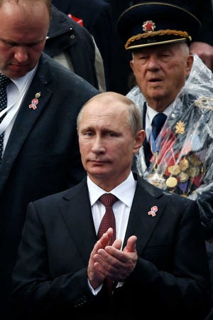 Vladimir Putin, Russia's president, claps as he attends a military parade in Belgrade, Serbia, Thursday, Oct. 16, 2014. Greeted by enthusiastic chants of "Putin! Putin!," Vladimir Putin attended a military parade Thursday in Slavic ally Serbia, where he held talks on economic issues, including on the South Stream gas pipeline opposed by the European Union. (AP Photo/Marko Drobnjakovic)