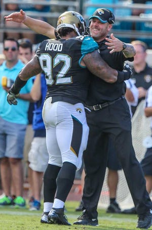 Gary McCullough for The Times-Union Defensive line coach Todd Wash greets tackle Ziggy Hood (92) at the sidelines.