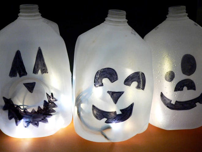 In this Friday, Oct. 10, 2014 photo, lighten up Halloween night with easy to make luminaries. Do-it-yourself projects include these milk jug ghosts, which are fast to craft. Detailed instructions are at the blog iSaveAtoZ. (AP Photo/Jennifer Forker)