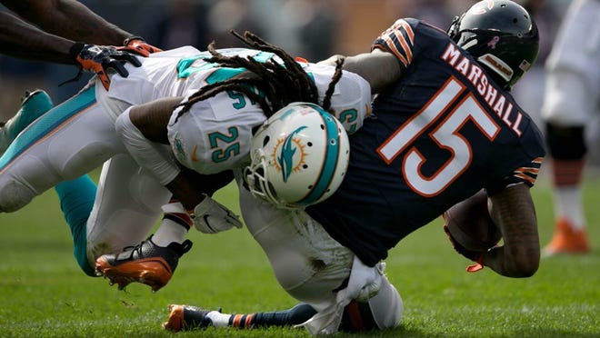 Miami Dolphins free safety Louis Delmas (25) drops Chicago Bears wide receiver Brandon Marshall (15) for a three yard loss in the second quarter at Soldier Field in Chicago, Illinois on October 19, 2014. (Allen Eyestone / The Palm Beach Post)