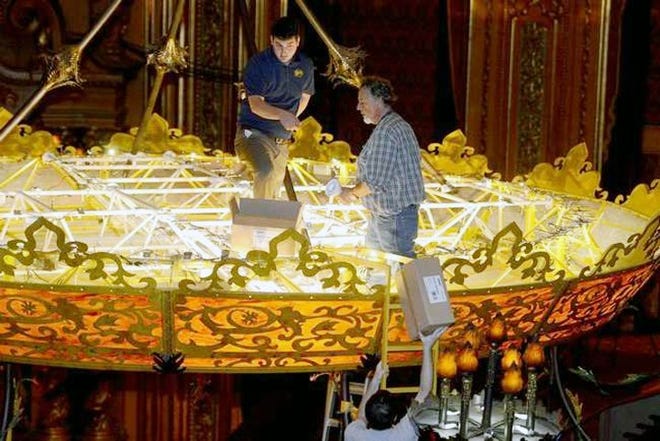 From left, Max Cohen and Tony Santucci of Meyda Tiffany Lighting get inside the LED chandelier after it was lowered for inspection and cleaning at the Stanley Center For The Arts in Utica Tuesday. GATEHOUSE NEW YORK PHOTO/TINA RUSSELL