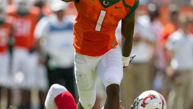 UM defensive back Artie Burns celebrates a sack against Cincinnati at Sun Life Stadium. Miami’s defense has been much better at home than on the road, where the competition has been far stiffer. (Allen Eyestone / The Palm Beach Post)