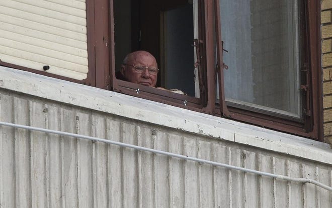 In this July 28 photo, Jakob Denzinger looks from his apartment window in Osijek, Croatia. Denzinger is among dozens of death camp guards and suspected Nazi war criminals who collected millions of dollars in Social Security payments despite being forced out of the U.S. An Associated Press investigation found dozens of suspected Nazi war criminals and SS guards who collected millions of dollars in Social Security payments after being forced out of the United States.