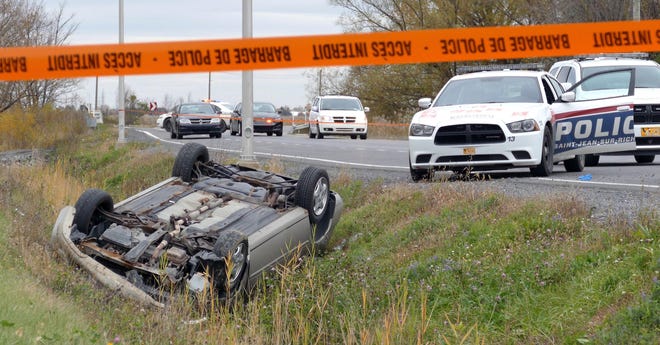 A car is overturned in the ditch in a cordoned off area in St-Jean-sur-Richelieu, Quebec on Monday Oct. 20, 2014. One of two soldiers hit by a car died of his injuries early Tuesday, according to Quebec provincial police. Provincial police say the man sped off in his car after hitting the two soldiers in the parking lot of a shopping mall, starting a chase that ended with the man losing control and his car rolling over several times. The driver died from police gunfire. The second soldier's injuries are described as less serious. (AP Photo/The Canadian Press,Pascal Marchand)