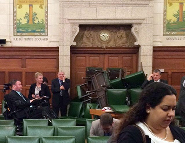 In this photo provided by MP Nina Grewal, members of Canada's Parliament barricade themselves in a meeting room on Parliament Hill on Wednesday in Ottawa.