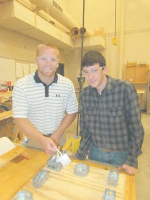 Teacher Michael Smith oversees the work of student Jonathon Horniak as he wires a light switch to control an outlet in the Basic Home Repair class at Waynesboro Area Senior High School.