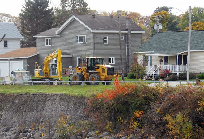 Construction vehicles are parked in front of homes on East German Street Extension on Friday. A town official said the town is finally able to move ahead with the construction project to repair its embankment. TELEGRAM PHOTO/STEPHANIE SORRELL-WHITE