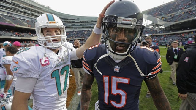 Dolphins quarterback Ryan Tannehill gives Chicago receiver Brandon Marshall a consoling pat on the helmet after Miami beat the Bears 27-14. Moments later, Marshall went on a loud rant in the locker room. (AP Photo/Charles Rex Arbogast)