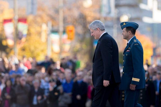 Justin Tang/The Canadian PressCanadian Prime Minister Stephen Harper, left, and General Tom Lawson, Chief of the Defence Staff of the Canadian Armed Forces, take part in a ceremony on Friday to return ceremonial guards to the Tomb of the Unknown Soldier at the National War Memorial in Ottawa, Canada.