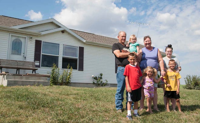 Buddy and Donna Smallwood, of Harveyville, stand outside of their farm home with five of their grandchildren, four of whom are living with the couple. Back row, from left, are Buddy, holding 1-year-old Paityn, Donna, and granddaughter Britney who doesn't live in the home. Front row, from left, are grandchildren Billy Don, 8, Lilianna, 3, and Andrew, 6.