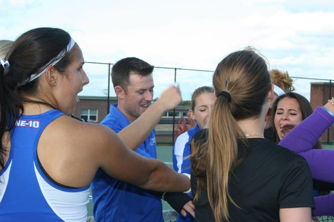 Assumption College women's tennis coach Dan Munsey celebrates with his players. For the first time in seven years, the team is moving on to the postseason.