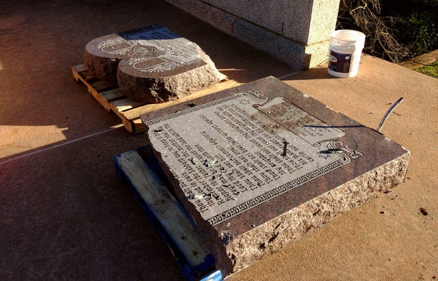The damaged remains of a Ten Commandments monument are gathered on the Oklahoma State Capitol grounds Friday, Oct. 24, 2014 in Oklahoma City. Authorities say someone drove across the Oklahoma Capitol lawn and knocked over the monument. The American Civil Liberties Union had been suing to have the monument removed, arguing it violates the Oklahoma Constitution. (AP Photo/Sean Murphy)
