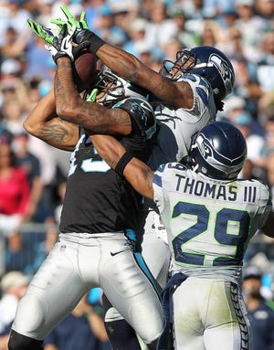 Panthers' wide receiver Kelvin Benjamin makes a catch between Seattle's Richard Sherman and Earl Thomas lll during the Panthers' 13-9 loss Sunday at Bank of America Stadium.