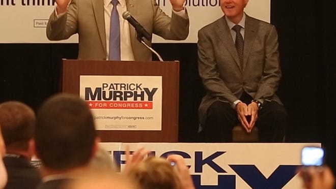 Former President Bill Clinton and Rep. Patrick Murphy, D-Jupiter, make their way onto stage in a ball room at the Palm Beach Gardens Marriott on Oct. 26, 2014 and prepare to address a crowd of Murphy supporters.