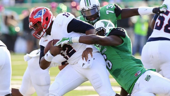 FAU quarterback Jaquez Johnson is tackled by Marshall’s Neville Hewitt during the Owls’ loss to the Thundering Herd 35-16 on Saturday. Johnson threw for 179 yards and a touchdown for FAU. (AP Photo/Randy Snyder)