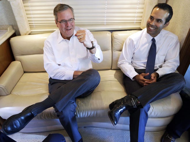 FILE - This Oct. 14, 2014, file photo shows George P. Bush reacting as his dad, former Florida Gov. Jeb Bush, left, gives a fist pump during an interview in Abilene, Texas. The younger Bush said in an interview with ABC's "This Week" Sunday, Oct. 26, 2014, that his dad is "moving forward" on a potential 2016 White House run and it appears more likely he'll join the Republican presidential field.