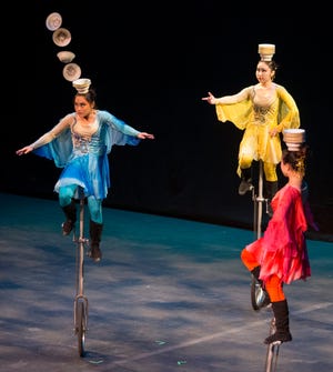 A performer with The National Acrobats of the People’s Republic of China catches bowls on her head while riding a tall unicycle Monday, Oct. 27, 2014, during a performance for a crowd for Rockford Public Schools fourth-grade students at the Coronado Performing Arts Center in Rockford.