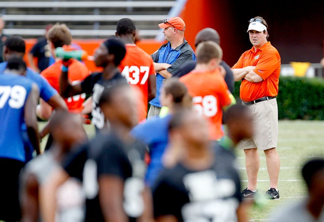 Florida coach Will Muschamp, right, watches drills during Friday Night Lights, a camp for high school players, at Ben Hill Griffin Stadium in July. Some of the nation's best players attended.