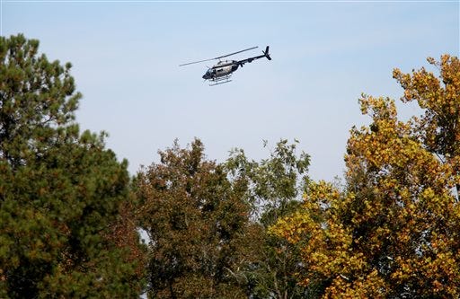 A N.C. Highway Patrol helicopter circles the Nash County courthouse and surrounding areas after two people were shot Tuesday, Oct. 28, 2014 in Nashivlle, N.C. Two people were shot outside the courthouse Tuesday and have non-life-threatening wounds and police were searching for two suspects, authorities said. Highway Patrol troopers were setting up a perimeter around a wooded area behind the courthouse, State Highway Patrol Lt. Jeff Gordon said.